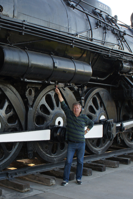 A photo of a man next to a steam engine